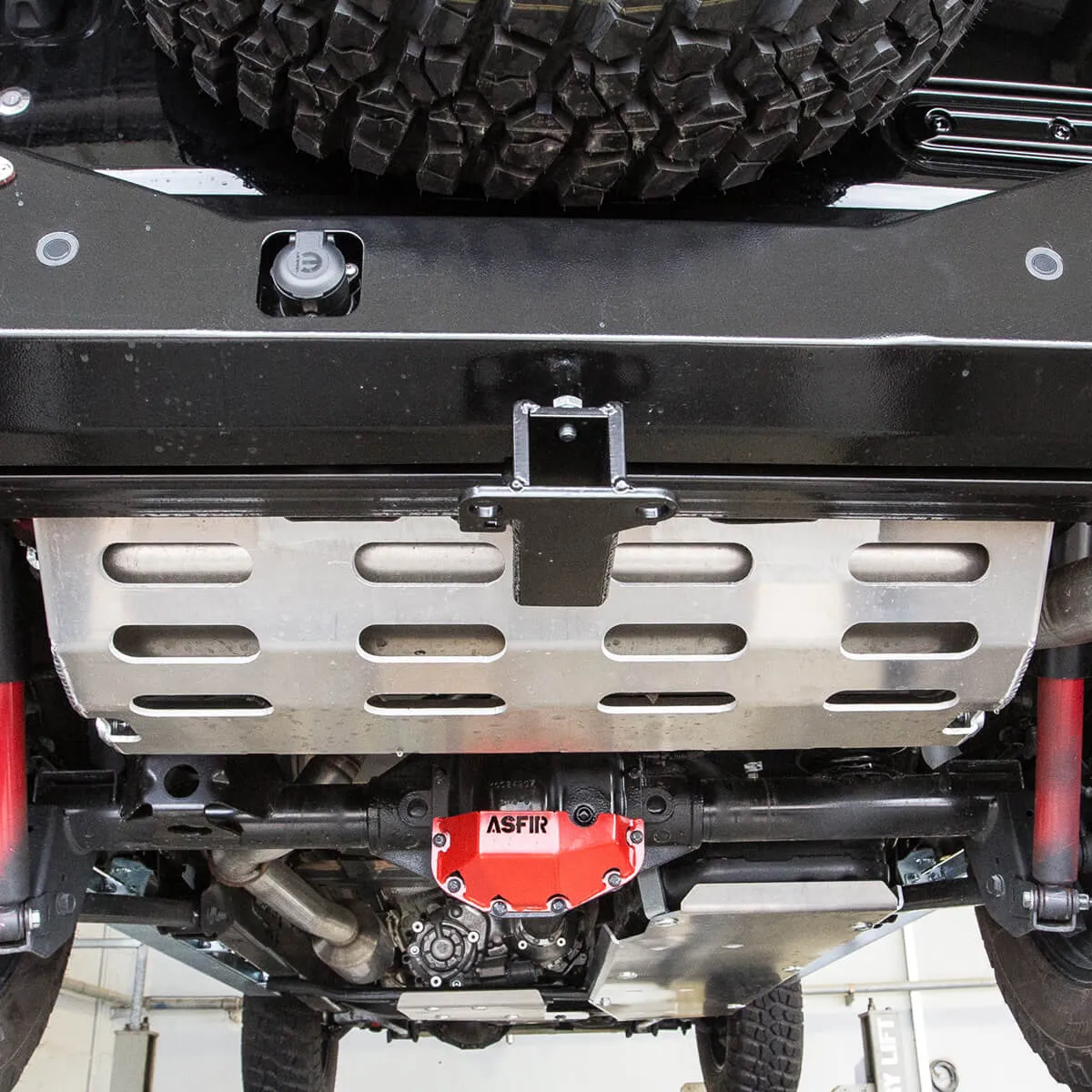 ASFIR skid plate and red differential guard under a Nissan truck