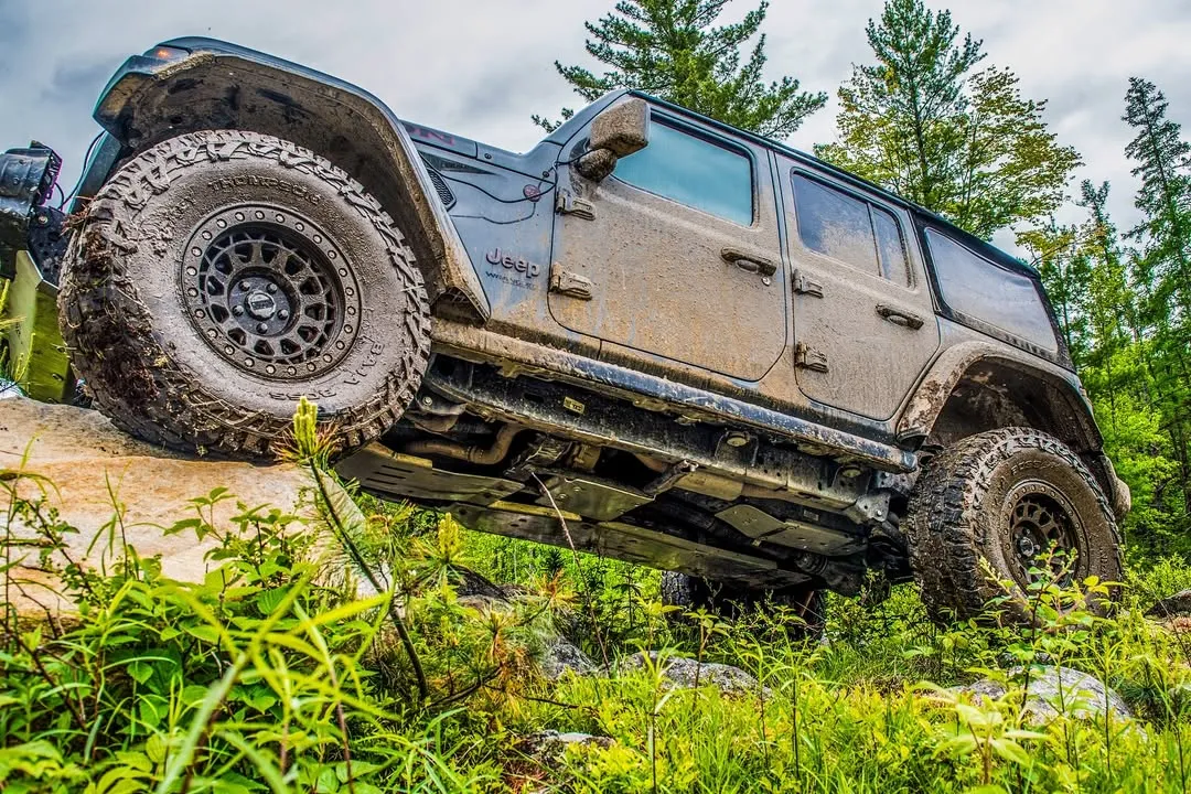 Nissan SUV climbing a ledge in the forest